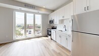 Located at 4066 Lexington Ave N in Shoreview, MN, this efficiently designed one-bedroom, one-bathroom residence offers a thoughtful layout across a single floor. The combined kitchen and living area serves as the heart of the unit, bathed in natural light from large floor-to-ceiling windows that frame open outdoor views. The kitchen is outfitted with white shaker-style cabinetry, a classic subway tile backsplash, light quartz countertops, a matte black faucet, and a full suite of stainless steel appliances including a range, dishwasher, microwave, and refrigerator. Light wood-tone flooring runs throughout the main living areas, lending warmth and continuity to the space. A bright hallway with sleek barn-style sliding doors connects the living area to the private bedroom, which features neutral carpet and a clean, minimalist aesthetic. The bathroom is well-appointed with a tub-shower combination, a single-sink vanity with white cabinetry, matte black fixtures, and wood-tone flooring. Additional conveniences include a dedicated closet, a laundry area, and a utility room, ensuring practical functionality throughout. The overall design is modern, clean, and move-in ready.