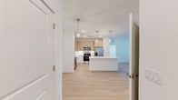 Located at 1305 Farkleberry Ln in Davenport, Florida, this well-designed 2-bedroom, 2-bathroom single-story home offers a clean, contemporary aesthetic throughout. Light wood-tone luxury vinyl flooring flows seamlessly across every room, creating a warm and cohesive look.

The open-concept kitchen is a standout feature, showcasing two-tone cabinetry with natural wood upper cabinets and white lower cabinets, crisp white quartz countertops, a textured tile backsplash, stainless steel appliances, and a large island with pendant lighting — ideal for both cooking and casual dining.

The kitchen opens to a bright living area filled with natural light from large windows and a glass door leading to an outdoor balcony. Ceiling fans are present in the main living spaces and bedrooms, adding comfort year-round.

The spacious primary bedroom includes access to a dedicated closet and an en-suite bathroom featuring a light wood vanity, white countertops, and a tiled shower-tub combo. The second bedroom is bright and airy, with a large window and generous proportions. The second bathroom mirrors the same modern finishes, with a matching vanity and clean lines throughout. Two closets provide practical storage across the home.