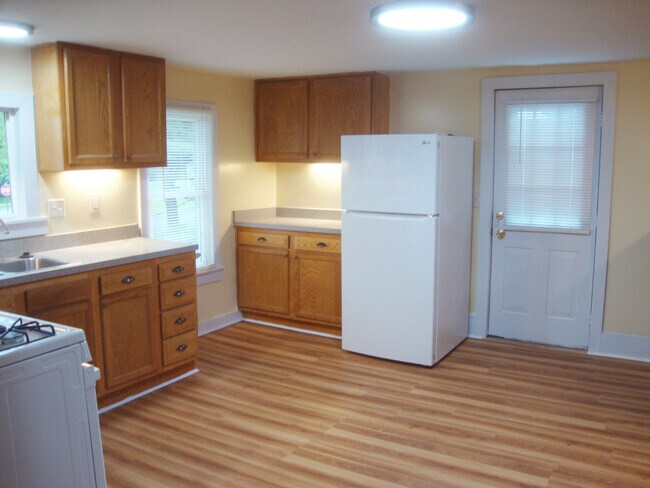 Cocina con refrigerador junto a la puerta de entrada. - 351 W Currant St