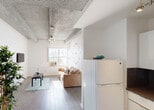 Situated in the heart of Miami Beach's vibrant Collins Avenue, this single-floor unit offers a well-organized layout that balances functionality with character. The living area is immediately welcoming, featuring wood-style flooring, crisp white walls, and a distinctive exposed concrete beam ceiling that adds an industrial aesthetic to the space. Natural light filters in through a front-facing window, brightening the living room, which comfortably accommodates a sofa and coffee table alongside a wall-mounted TV.

The kitchen is efficiently designed in an L-shaped configuration, outfitted with white cabinetry, dark granite countertops, a gas range, and a built-in microwave — providing everything needed for everyday meal preparation. A full-size refrigerator is conveniently accessible near the living area.

The bedroom is a calm and restful retreat, featuring the same exposed beam ceiling detail seen throughout the unit, along with a closet and direct access to the bathroom. The bathroom is cleanly appointed with a combined tub and shower, a single vanity with gold-tone fixtures, and a wall mirror.

This compact yet complete unit offers a practical base steps away from Miami Beach's iconic beaches, restaurants, and nightlife, making it an ideal choice for those seeking convenience in one of South Florida's most sought-after neighborhoods.