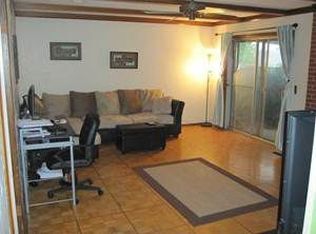 Sala de estar con puerta de patio, chimenea a gas y pisos de madera. - 4401 Northwest 55th Street