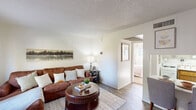 Located at 1150 West University Drive in Tempe, Arizona, this efficiently designed one-bedroom, one-bathroom unit offers a thoughtful layout across a single floor. The living room serves as the heart of the space, featuring wood-look flooring, neutral walls, and a window that invites natural light — creating a warm and welcoming atmosphere. A textured ceiling adds subtle character throughout.

The bedroom is a comfortable retreat finished with plush carpeting, a window dressed with curtains that allow natural light to filter in, and direct access to a dedicated closet with built-in shelving — providing practical storage. The room's light tones and clean lines contribute to a calm, restful ambiance.

The bathroom is neatly appointed with a wood-toned vanity, stone-finish countertop, and a tub-shower combination. Decorative hexagonal mirrors add a modern touch to the white walls, completing the clean aesthetic.

The unit also features a versatile area suitable for a home office or dining space, with wood-look flooring consistent with the living area. Throughout the home, the cohesive neutral palette and functional design make efficient use of the available space, offering a practical and comfortable living environment in the heart of Tempe near Arizona State University.