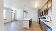 Located in Freeport, FL, this well-appointed 3-bedroom, 2-bathroom single-story home offers a thoughtfully designed layout across a comfortable footprint. The open-concept kitchen and living area serves as the heart of the home, featuring a central island with white quartz countertops, warm-toned cabinetry, a classic subway tile backsplash, and a full suite of stainless steel appliances including a gas range, microwave, refrigerator, and dishwasher. Stylish pendant lighting over the island and track lighting above the cooking area add a modern touch. Light luxury vinyl plank flooring runs throughout, complementing the clean, neutral palette of the interior.

The living area flows naturally from the kitchen and is brightened by large windows that invite ample natural light. The generously sized primary bedroom includes a ceiling fan and an outdoor-facing door, while the secondary bedrooms are bright and well-proportioned, each with ceiling fans and windows offering neighborhood views. The two bathrooms are finished with dark cabinetry, white countertops, and ample vanity space. A dedicated in-unit laundry room houses a full-size washer and dryer. Two hallways connect the living spaces efficiently, rounding out a functional and modern home.