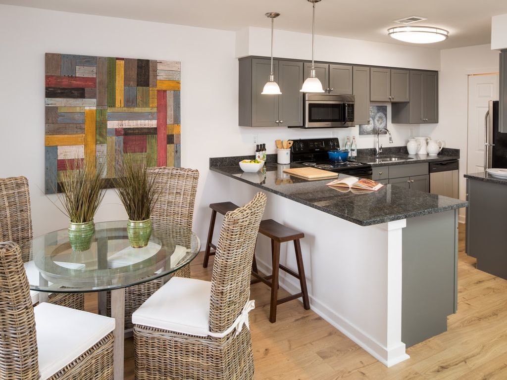 Apartment kitchen with stainless steel, granite countertops, and dark cabinetry - Yardley Crossing Luxury Apt and Townhomes