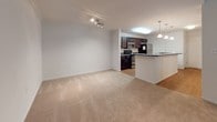 Located at 4100 Lonas Pkwy in Midlothian, Virginia, this single-floor residence offers a well-designed layout with a seamless blend of comfort and functionality. The open-concept living and kitchen area serves as the heart of the home, where neutral-toned carpet flows through the spacious living room, accented by crown molding and track lighting overhead. A sliding glass door brings in natural light and provides access to the outdoors. The kitchen is appointed with dark espresso cabinetry, granite-style countertops, stainless steel appliances including a range, microwave, and refrigerator, and a built-in dishwasher. A peninsula with pendant lighting above creates a natural division between the kitchen and living space, ideal for casual dining or entertaining. Wood-look flooring runs throughout the kitchen, adding warmth and visual contrast. The bedrooms are generously sized, each featuring soft carpeting and windows dressed with white blinds that allow ample natural light while maintaining privacy. The full bathroom is thoughtfully finished with a dark wood vanity, light countertop, and a tub-shower combination, all set on wood-look tile flooring. Throughout the residence, a clean, neutral color palette creates a bright and inviting ambiance.