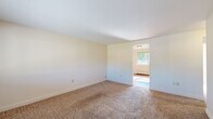 Located at 1719 Hunt Rd in Reading, Ohio, this single-floor unit offers a straightforward and functional layout spread across several well-defined living spaces. The living room serves as the main gathering area, featuring neutral carpet flooring, a large front-facing window that allows natural light to fill the room, and a direct entry door with tile flooring at the threshold. Baseboard heating is present throughout the unit, ensuring consistent warmth year-round. The kitchen is equipped with warm oak cabinetry offering ample storage, white countertops, a double stainless steel sink, and a white electric range with an overhead exhaust fan. The hardwood flooring in the kitchen adds a classic touch. The bedrooms are carpeted and bright, with multiple windows providing natural light and outdoor views of the surrounding neighborhood. Ceiling fans with integrated lighting are featured in select bedrooms, along with window air conditioning units for cooling. One room showcases charming board-and-batten wainscoting with rich hardwood floors, adding character to the space. The full bathroom features white tile flooring, a bathtub with shower, a toilet, and a vanity with wood cabinetry, all finished in a clean, neutral palette.