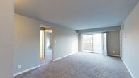 This single-floor unit at 2502 Edgecombe Circle North in Baltimore, Maryland offers a straightforward and functional layout designed for comfortable everyday living. The living area is generously sized, finished with neutral gray carpet and light gray walls that create a clean, understated aesthetic. A sliding glass door opens to a private balcony, allowing natural light to fill the space and providing views of surrounding greenery. A ceiling-mounted HVAC vent and thermostat panel reflect practical, built-in climate control throughout.

The galley-style kitchen features warm-toned wood cabinetry, granite-style countertops, and wood-look flooring. White appliances, including a gas range and a full-size refrigerator, are included, making the space move-in ready.

The bedrooms are carpeted and finished in neutral tones, offering a calm atmosphere. One bedroom benefits from a wide window with outdoor views, while another features access to a closet. Both rooms provide a comfortable and adaptable setting.

The bathroom includes a full soaking tub and shower combination with clean white surround panels and chrome fixtures. Throughout the unit, white baseboards and consistent neutral finishes contribute to a cohesive, well-maintained interior.