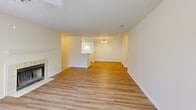 Located at 930 E Main St in Lexington, SC, this single-floor, one-bedroom, one-bathroom residence offers a well-organized layout designed for comfortable everyday living. The combined kitchen and living room serves as the heart of the home, where light hardwood-style flooring, a ceiling fan, and large windows invite generous natural light and outdoor views. A classic fireplace anchors the living area, adding warmth and character. A dedicated dining area is illuminated by an elegant chandelier, while the open sightline into the kitchen keeps the space feeling connected and airy. The galley-style kitchen features white cabinetry, white appliances including a range, refrigerator, and dishwasher, along with light countertops and hardwood-style flooring, providing a clean and functional workspace. The bedroom is a comfortable retreat finished with plush carpet, a textured ceiling, and a window overlooking a balcony, offering a quiet, private atmosphere. A dedicated closet provides practical storage. The bathroom is well-appointed with a white vanity topped with a stone-look countertop, a large mirror, and a full tub-shower combination, all set on light wood-look flooring. Neutral tones and textured ceilings throughout give the space a cohesive, move-in-ready appeal.