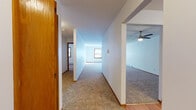 Located at 78 Kessel St in Madison, Wisconsin, this single-floor unit offers a practical and comfortable layout designed for everyday living. The kitchen is well-appointed with white cabinetry, gray laminate countertops, wood-look flooring, black appliances including a refrigerator, range, and dishwasher, and a mirrored backsplash that adds depth to the space. A dedicated sink area with under-counter storage and a built-in desk-height counter section provides added functionality.

The living and hallway areas feature wall-to-wall neutral carpeting throughout, clean white walls, and wood-trimmed doors that lend a warm, classic feel. Baseboard heating units run along the perimeter of multiple rooms, ensuring consistent warmth. A ceiling fan is installed in the living area, contributing to year-round comfort. Natural light enters through wood-framed windows fitted with blinds in the bedrooms and common areas.

The bedrooms are generously sized with ample floor space, neutral carpeting, and baseboard heating. The bathroom includes a white vanity with gray countertop, a large mirror, tile flooring, and a walk-in shower stall. The overall layout, as seen in the dollhouse view, is open and efficiently organized, making this a well-structured and move-in ready space.