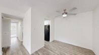 Located at 301 Pine Valley Rd in Jacksonville, NC, this two-bedroom, one-bathroom single-floor home offers a clean, updated interior with a practical and functional layout. The living room is a bright, open space featuring light-toned luxury vinyl plank flooring, a ceiling fan with integrated lighting, and a sliding glass door that fills the room with natural light and provides direct outdoor access. A louvered closet door adds convenient built-in storage to the living area. The kitchen is well-appointed with white shaker-style cabinetry, granite-look countertops, a double-basin stainless steel sink, and black appliances including an electric range and refrigerator, complemented by a range hood and dishwasher. The primary bedroom is generously sized and features dual bifold closets, offering ample storage. Both bedrooms are finished with plush carpeting and receive natural light through windows with blinds. The full bathroom includes a tub-shower combination, a vanity with white cabinetry, and wood-look vinyl flooring. Throughout the home, crisp white walls and consistent finishes create a cohesive, move-in-ready aesthetic suited for comfortable everyday living.