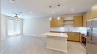 Located at 1224 Old Peachtree Road Northeast in Lawrenceville, GA, this modern one-bedroom, one-bathroom residence offers a thoughtfully designed open-concept layout with clean lines and a bright, neutral palette throughout. Light wood-tone luxury flooring flows seamlessly across the entire space, enhancing the airy ambiance.

The kitchen is a standout feature, outfitted with flat-front wood cabinetry, crisp white quartz countertops, a textured tile backsplash, and a full suite of stainless steel appliances including a range, microwave, dishwasher, and refrigerator. A central island with pendant globe lighting above provides additional prep and dining space, while open shelving adds a modern, functional touch.

The living area opens directly from the kitchen, bathed in natural light from a glass-panel exterior door. A ceiling fan adds comfort to the space. The bedroom is generously sized, featuring a window that invites natural light and a ceiling fan overhead. Two closets, including a walk-in with built-in wire shelving, offer ample storage.

The bathroom is elegantly appointed with a wide wood-vanity, white quartz countertop, framed mirror, pendant lighting, and a marble-accented shower enclosure. A built-in mudroom nook near the entry provides convenient everyday storage with a bench and hooks.