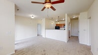 This well-appointed two-bedroom, three-bathroom single-floor residence at 1021 Stoneridge Dr in Seymour, Indiana offers a thoughtfully designed layout with comfortable living spaces throughout. The open-concept living and dining area is anchored by a ceiling fan, plush carpeting, and abundant natural light from large windows with blinds and a sliding glass door that opens to a private balcony with outdoor views. The kitchen features warm wood cabinetry, a raised breakfast bar with pendant lighting, and black appliances, creating a functional and welcoming space. The primary bedroom is generously sized with soft carpeting, direct access to an en-suite bathroom, and a walk-in closet equipped with wire shelving for ample storage. The primary bathroom is finished with a dual-sink granite-topped vanity, rich wood cabinetry, tile flooring, and a walk-in shower with built-in shelving. The second bedroom is bright and carpeted, with a large window that fills the room with natural light. Two hallways connect the spaces efficiently, and two closets provide additional storage. The home's clean, neutral color palette and consistent finishes create a cohesive and move-in-ready ambiance throughout.