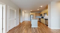Located at 7326 Wallace Rd in Charlotte, NC, this single-floor residence offers a clean, contemporary design throughout. The open-concept layout centers around a well-equipped kitchen featuring light wood cabinetry, granite countertops, a central island, and a full suite of stainless steel appliances including a refrigerator, range, microwave, and dishwasher. Recessed lighting and warm-toned, wood-look luxury vinyl plank flooring flow seamlessly through the main living area, creating a bright and cohesive atmosphere.

The bedrooms are generously proportioned, each receiving ample natural light through large windows fitted with blinds that offer views of the surrounding greenery. The neutral wall tones and clean lines of each room provide a versatile canvas for any style of furnishing.

The bathroom is thoughtfully designed with a double-sink granite vanity, wood-tone cabinetry, and a soaking tub. It connects directly to a spacious walk-in closet outfitted with multi-tiered wire shelving and hanging rods, offering substantial storage. An additional bathroom includes a walk-in closet as well, further enhancing the unit's storage capacity. Throughout the space, consistent flooring, crisp white trim, and a neutral palette contribute to a modern, well-maintained aesthetic.