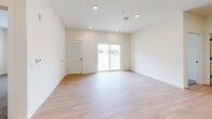 Located at 15 Ore Bank Rd in Dillsburg, PA, this single-floor home offers a thoughtfully designed layout across a comfortable footprint. The interior features a clean, modern aesthetic with neutral tones, light hardwood-style flooring in the main living areas, and plush carpet in the bedrooms.

The open-concept kitchen and living room serve as the heart of the home. The kitchen is outfitted with gray shaker-style cabinetry, white quartz countertops, stainless steel appliances including a range, microwave, and refrigerator, and a central island with a built-in sink and pendant lighting above. The living area extends from the kitchen and features recessed lighting and a sliding glass door that brings in natural light and outdoor views.

The generously sized primary bedroom provides ample space, while the two additional bedrooms feature carpeted floors and windows with natural light. One bedroom includes light hardwood-style flooring and a louvered closet door. The two bathrooms maintain the home's consistent style, featuring gray vanity cabinetry, white countertops, and light hardwood-style flooring. One bathroom includes a walk-in shower, while the other offers a tub-shower combo.

A dedicated laundry room with included washer and dryer units completes the home's functional layout.