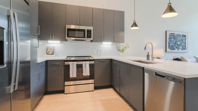 Kitchen with Stainless Steel Appliances and Dark Cabinets - Alexan Harrison