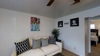 This single-story, 2-bedroom, 1-bathroom unit offers a well-utilized layout designed for comfortable everyday living. The living area serves as the heart of the home, featuring neutral-toned walls that create a clean, versatile backdrop suitable for a variety of décor styles. Carpeted flooring adds warmth underfoot, while a ceiling fan provides both functional air circulation and a subtle design element overhead. The space is thoughtfully scaled, providing enough room for seating and lounging without feeling excessive. Wall space is generously available for artwork and personalization, as seen in the room's framed décor and colorful canvas accents. The overall ambiance is relaxed and inviting, with a layout that maximizes the available square footage across its two bedrooms and shared bathroom. The single-floor design ensures easy accessibility throughout, making it a practical and straightforward living space. Whether used as a primary residence or a comfortable retreat, this unit balances simplicity with functionality in a compact, manageable footprint.