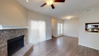 This single-story residence at 5406 Burnham Dr in Corpus Christi, TX offers a well-designed layout with a blend of comfort and functionality. The open living area is a standout, featuring vaulted ceilings, a ceiling fan, and a brick fireplace flanked by a sliding glass door that floods the space with natural light and provides outdoor access. Wood-look flooring extends throughout the main living areas, complementing the neutral color palette.

The galley-style kitchen is efficiently designed with dark espresso cabinetry, light countertops, a full suite of appliances including a range, microwave, and refrigerator, and a double sink — offering ample storage and prep space.

The bedrooms feature plush carpeting, natural light from blinded windows, and closet storage, including louvered and panel-door options. The bathrooms are equipped with wood-look flooring, dark vanity cabinetry, and light countertops. One bathroom includes a soaking tub, while another features an extended vanity with overhead cabinetry. A hallway connects the private areas of the home, maintaining a logical and functional flow throughout the single-floor layout.