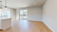 Located at 7831 E Union Ave in Denver, CO, this well-appointed single-floor residence offers three bedrooms and two bathrooms across a thoughtfully designed layout. Light wood-tone flooring flows throughout the main living areas, complementing the neutral gray and white color palette that gives the home a clean, contemporary feel.

The open-concept living, dining, and kitchen area serves as the heart of the home. The kitchen is a standout feature, outfitted with white shaker cabinetry accented by matte black hardware, a white subway tile backsplash, quartz countertops, stainless steel appliances, and a large center island with pendant lighting. Large windows and a sliding glass door in the living room flood the space with natural light and open to a private balcony with views of the surrounding Denver skyline.

Both bathrooms are finished with wood-look flooring, white vanities with quartz countertops, and black hardware accents. One bathroom features a glass-enclosed walk-in shower with marble-style tile, while the second offers a tub-shower combo with matching tile surround.

The three bedrooms are generously proportioned, with the secondary rooms featuring soft carpet and ample natural light. A central hallway connects the private quarters, and four closets, a dedicated laundry area, and a utility room provide exceptional storage throughout.