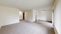 Located in Salem, Oregon, this two-bedroom, one-bathroom residence offers a practical and well-organized single-floor layout. The interior is finished with a neutral color palette, creating a clean and cohesive look throughout. The open living area features plush carpeting, a ceiling fan, textured ceilings, and a baseboard heating system. A large window brings in ample natural light and offers views of the surrounding greenery, adding a sense of openness to the space. The galley-style kitchen is efficiently designed with white cabinetry lining both sides, light wood-look flooring, and white appliances including a refrigerator, electric range, and a stainless steel sink — providing functional workspace for everyday cooking. The spacious primary bedroom is generously sized, carpeted, and features a window with natural light and a baseboard heater, while the second bedroom also offers carpet flooring and its own window overlooking outdoor greenery. The full bathroom includes a clean, white tub-shower combination with modern fixtures and a vanity. A dedicated utility room houses the water heater and includes washer/dryer hookups, adding convenience for in-unit laundry. The hallway connects all areas of the home seamlessly, completing this well-appointed residential space.