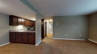 Located at 529 E Main St in Ravenna, Ohio, this single-floor unit offers a well-designed layout that balances functionality and comfort throughout. The entryway is defined by a striking exposed brick wall, lending a classic, durable character to the space as you step inside onto plush carpeting.

The open-concept living area flows seamlessly into the kitchen, which is outfitted with rich dark-wood cabinetry, granite-style countertops, hardwood-style flooring, and stainless steel appliances including a dishwasher and range. Ample upper and lower cabinet storage makes this kitchen as practical as it is attractive, with under-cabinet lighting adding a polished touch.

The living area is generously proportioned, painted in calming sage green tones, and features baseboard heating for year-round comfort. A central hallway connects the living space to the private areas of the unit.

Two carpeted bedrooms are situated toward the rear, each painted in neutral tones and featuring windows that allow natural light to fill the rooms. Baseboard heaters are present in both bedrooms, ensuring consistent warmth.

The full bathroom is clean and functional, featuring wood-style tile flooring, a combined tub and shower unit, a toilet, and a vanity with granite-style countertop and dark wood cabinetry, consistent with the kitchen aesthetic. Overall, this unit presents a cohesive, well-maintained interior suited for comfortable everyday living.