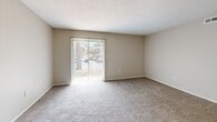 Located at 3500 Pelham Rd in Greenville, SC, this single-floor, three-bedroom, one-bathroom residence offers a practical and well-organized layout. The living room features soft carpet flooring and a sliding glass door that fills the space with natural light while providing outdoor views. The flooring transitions to hardwood in the hallway, connecting the living area to the kitchen and bedrooms seamlessly. The kitchen is outfitted with granite-style countertops, dark cabinetry with a tile backsplash, and stainless steel appliances including a full-size refrigerator. Each of the three bedrooms is carpeted and features ceiling fans, neutral wall tones, and closets with built-in shelving for storage. The primary bedroom includes two closets and direct access to the hallway. The secondary bedrooms are bright and well-proportioned, each with a window fitted with blinds. The bathroom includes a granite-topped vanity, a framed mirror, and a shower with a curtain enclosure. Throughout the home, neutral beige tones and clean white trim create a consistent, cohesive aesthetic. Textured ceilings are present in several rooms, adding subtle architectural character to this efficiently designed residence.