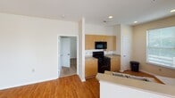 Located on Steelecroft Parkway in Charlotte, NC, this single-story unit offers a well-designed, open-concept layout with a bright and functional interior. The living and dining areas share a generous, flowing space highlighted by warm wood-style flooring, neutral beige walls, and a ceiling fan overhead. Multiple windows fitted with horizontal blinds allow natural light to fill the space, and French doors provide additional brightness while offering access to the outdoors.

The kitchen is efficiently arranged with light wood cabinetry, stone-toned countertops, and black appliances including a gas range, built-in microwave, refrigerator, and sink. A peninsula counter separates the kitchen from the main living area, creating a practical divide while maintaining the open feel of the space.

The bedrooms feature plush wall-to-wall carpeting and windows with outdoor views, lending each room a comfortable and quiet atmosphere. The bathrooms include a full bath with a soaking tub and an additional bathroom equipped with a glass-enclosed walk-in shower, wood-style flooring, and stone-toned countertops. A laundry closet is also present within the unit. Overall, the space presents a clean, practical, and light-filled environment suited for everyday living.