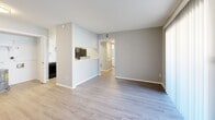 Located in the Covington Hills neighborhood of Memphis, Tennessee, this single-floor home offers a clean, modern interior with a neutral gray color palette throughout. The living area is bright and open, featuring light wood-look luxury vinyl flooring that extends into the hallway and kitchen. A large sliding glass door floods the living space with natural light and provides outdoor access. The kitchen is well-appointed with crisp white cabinetry, marble-look countertops, a black refrigerator, and additional appliances, all set atop matching light wood-look flooring. A half-wall pass-through connects the kitchen to the living area, creating an open and functional layout. The bedrooms are carpeted and equipped with ceiling fans, offering a comfortable atmosphere. Each bedroom benefits from natural light via window blinds and offers closet space, including a spacious walk-in closet outfitted with double hanging rods and shelving for ample storage. The bathroom features wood-look flooring, a soaking tub, marble-look vanity countertop, and a lighted mirror. A hallway connects all areas of the home, providing a logical and efficient flow throughout this well-maintained single-level residence.
