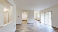 This single-floor, 1-bedroom, 1-bathroom unit offers a practical and efficient layout designed to maximize everyday comfort. The open-concept living and kitchen area serves as the heart of the home, with light wood-look luxury vinyl flooring running throughout the main living spaces, creating a clean and cohesive aesthetic. The living room is bright and airy, featuring a ceiling fan, a sliding glass door covered by vertical blinds that allows natural light to fill the space, and a pass-through window connecting to the kitchen area.

The kitchen is equipped with ample white upper cabinetry reaching toward the ceiling for generous storage, warm-toned countertops, a stainless steel sink, an electric range, and a full-size refrigerator. A peninsula-style counter separates the kitchen from the living area, providing additional workspace and a casual dining option.

The bedroom offers a comfortable retreat with plush carpeting, a sizable window with outdoor greenery views, a baseboard heater, and a sliding-door closet with built-in shelving and a hanging rod. The full bathroom features wood-look tile flooring, a single-sink vanity with storage cabinetry, a large mirror, and a shower-tub combination. The unit's neutral color palette and clean finishes provide a move-in-ready environment throughout.