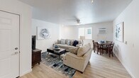 Located in Pleasant Hill, Iowa, this single-floor, three-bedroom, two-bathroom home offers a well-organized layout that balances comfort and functionality. The combined kitchen and living area serves as the heart of the home, with the living room featuring light hardwood-style flooring, a ceiling fan, and a naturally lit, open feel. The kitchen is outfitted with dark, rich cabinetry, light stone-look countertops in an L-shaped configuration, and white appliances, including a range and refrigerator.

The primary bedroom is a generously sized retreat with ample room for furnishings. The two additional bedrooms feature plush carpeting, ceiling fans, and windows that bring in natural light—each offering a cozy, functional space. Two closets provide added storage throughout the home.

Both bathrooms are finished with the same dark cabinetry and light countertops found in the kitchen, paired with light hardwood-style flooring. One bathroom includes a shower-tub combo, while the other features a walk-in shower. A dedicated utility room rounds out the floor plan, adding practical storage and laundry capability. Clean white walls and consistent finishes throughout give the home a cohesive, move-in-ready appeal.