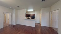 Located at 3201 W Loop 289 in Lubbock, Texas, this single-floor residence offers a straightforward and functional layout designed for comfortable everyday living. The entry opens through a solid paneled front door into a bright living area finished with rich wood-look flooring that extends throughout the main living spaces. Tall, narrow windows fitted with horizontal blinds allow natural light to fill the room while maintaining privacy, creating a clean and welcoming atmosphere against the neutral, light-toned walls.

The bedroom is finished with plush wall-to-wall carpeting, offering a comfortable and quiet retreat. A ceiling fan with integrated lighting provides both airflow and illumination, while a window with exterior views keeps the room feeling open and connected to the outdoors.

The bathroom is efficiently designed, featuring dark espresso-toned cabinetry with an overhead storage cabinet, a single vanity with sink and countertop, a full tub-shower combination, and wood-look flooring that ties the space together cohesively. The layout is practical and well-organized, making the most of the available space.

Overall, this residence presents a clean, move-in ready environment with consistent finishes, ample natural light, and a neutral color palette that accommodates a variety of interior styles.