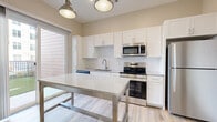 Located at 3700 Monument Avenue in Richmond, Virginia, this well-designed one-bedroom, one-bathroom residence offers a thoughtfully laid-out single-floor plan with modern finishes throughout. The open-concept kitchen is a standout feature, outfitted with white shaker-style cabinetry, granite countertops, a subway tile backsplash, and a full suite of stainless steel appliances including a range, microwave, dishwasher, and refrigerator. Pendant lighting and a sliding glass door to the exterior fill the space with natural light, while light wood-style flooring ties the living and kitchen areas together seamlessly. The bedroom is carpeted for comfort, featuring a large window with views of the surrounding neighborhood and ample wall space. A generously sized walk-in closet with built-in wire shelving provides excellent storage. The bathroom is finished with white cabinetry, granite countertops, a large vanity mirror, and a tiled walk-in shower with a clean, contemporary aesthetic. Wood-look flooring continues into the bathroom, maintaining a cohesive design. This residence combines practical functionality with modern style in a prime Richmond location.