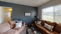 This single-floor home on Mayberry Street in Fort Wayne, Indiana, offers a well-organized layout with multiple bedrooms, a practical kitchen, an inviting living room, and a full bathroom. The living room makes a strong impression with its deep slate-blue accent wall, carpet flooring, and a window that fills the space with natural light — an ideal setting for relaxing or entertaining. The kitchen is outfitted with warm oak cabinetry, dark countertops, a white dishwasher, a gas range, and durable tile flooring, providing ample storage and workspace. The home features multiple bedrooms, each carpeted and bathed in natural light from sizable windows. The primary bedroom is spacious and bright, with two windows, neutral walls, and room for a full dresser suite. Secondary bedrooms offer similarly comfortable accommodations with carpet flooring and good window coverage. The full bathroom is cleanly appointed with a white vanity, tile flooring, and a tub-shower combination. Textured ceilings are consistent throughout the home. Overall, this property delivers a practical and comfortable living environment suited for a range of occupants.