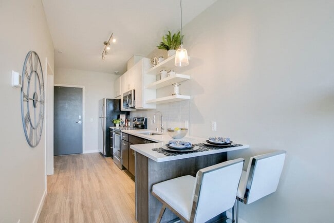 The kitchen in this studio layout offers a breakfast bar with seating space. - The Central