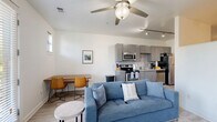 Located at 1016 18th Ave S in Nashville, TN, this single-floor unit offers a well-organized layout that efficiently combines everyday living spaces. Light wood-style flooring runs throughout, creating a cohesive and clean aesthetic from room to room.

The kitchen is a functional highlight, outfitted with gray shaker-style cabinetry, granite countertops, a subway tile backsplash, and a full suite of stainless steel appliances including a refrigerator, electric range, microwave, and dishwasher. Track lighting overhead and a window allow natural light to fill the space. The kitchen flows directly into a combined dining and living area, where a ceiling fan, multiple windows, and a glass door leading to a private balcony bring in ample natural light and views of the surrounding greenery.

The living area provides a comfortable, open setting with enough room for a sofa, accent chair, coffee table, and entertainment unit. The private balcony access adds an outdoor dimension to the living space.

The bathroom features a clean, minimalist design with wood-plank-style tile flooring, a modern vanity with under-cabinet storage, a wall-mounted mirror, and a shower-tub combination. White walls and well-placed lighting contribute to a bright, tidy feel. The unit also includes a dedicated sleeping area visible in the floorplan, completing a practical and thoughtfully designed layout.