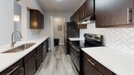 This apartment showcases a blend of modern design and practical amenities. The kitchen boasts dark wood cabinetry, stainless steel appliances, and a stylish herringbone backsplash. Spacious bedrooms feature plush carpeting and large windows, allowing ample natural light. The bathroom combines functionality with style, offering a shower/tub combo and updated fixtures. A dedicated laundry area with a full-sized washer adds convenience. Throughout the unit, neutral tones and ceiling fans create a fresh, inviting atmosphere. The open-concept layout seamlessly connects living areas, enhancing the sense of space in this contemporary Lawrenceville residence.