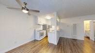 Located at 14350 Vanowen St in Los Angeles, CA, this one-bedroom, one-bathroom unit offers a practical and efficient single-floor layout. The open-concept living and kitchen area forms the heart of the home, featuring warm hardwood-style flooring, a textured ceiling, and a ceiling fan with integrated lighting. A large window allows natural light to fill the living space, which also includes a wall-mounted air conditioning unit for year-round comfort. The kitchen is designed in a galley style, lined with white cabinetry both above and below the counter, and equipped with a gas range, stainless steel refrigerator, and a double sink with ample counter space — all complemented by a half-wall partition that defines the space without closing it off. The spacious bedroom features hardwood-style flooring, a wide window with views of surrounding greenery, and a full-width mirrored sliding closet that enhances the sense of space. Direct access to the bathroom is conveniently located off the bedroom. The bathroom includes a combined tub and shower, a toilet, and a vanity with a granite-style countertop and mirrored medicine cabinet. Clean white walls and consistent flooring throughout the unit create a cohesive and neutral aesthetic.