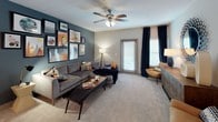 Located at 6008 Lewis St in Charlotte, NC, this single-floor residence offers a thoughtfully designed layout with contemporary interiors throughout. The living room serves as a standout centerpiece, featuring a deep teal accent wall adorned with an eclectic gallery of framed artwork, plush carpeting, a ceiling fan, and access to a private exterior door with window treatments that allow natural light to filter in. The kitchen is well-appointed with rich dark cabinetry, granite-style countertops, wood-look flooring, and stainless steel appliances, providing ample storage and prep space. The home includes multiple bedrooms, each distinctively styled with ceiling fans, large windows with blinds and curtains, and soft carpeting. One bedroom features a bold teal accent wall with framed art above the bed, while another showcases patterned wallpaper, a natural wood bed frame, and layered textiles for a cozy atmosphere. The bathrooms include a primary bath with wood-look flooring, a glass-enclosed shower, and a vanity with dark cabinetry, as well as a secondary bath with a soaking tub and shower combination. A dedicated in-unit laundry area with a full-size washer and dryer adds everyday convenience to this well-appointed Charlotte residence.
