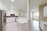 Located at 1029 W 223rd St in Torrance, CA, this well-appointed 2-bedroom, 2-bathroom residence offers a thoughtfully designed single-floor layout with modern finishes throughout. The open-concept kitchen and living area serves as the heart of the home, featuring crisp white cabinetry, a striking mosaic tile backsplash, a large white quartz peninsula, stainless steel appliances including a refrigerator and dishwasher, and light large-format tile flooring. Recessed lighting illuminates the space, while an adjacent living area benefits from warm wood-look flooring and a generous window that invites natural light and outdoor views. Both bedrooms are comfortably sized, with the primary bedroom offering a dedicated closet accessible via a private hallway. The bedrooms feature the same warm wood-look flooring and neutral walls, creating a calm and restful atmosphere. One bedroom includes a sliding glass door leading to an outdoor area. The two bathrooms mirror each other in design, each finished with light stone-look tile flooring, white cabinetry with brushed nickel hardware, a full bathtub with shower, and a well-lit vanity mirror. A hallway and closet complete the floor plan, adding practical storage and connectivity throughout this clean, move-in-ready Torrance residence.