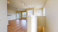 Located at 1699 Chatham Pkwy in Savannah, GA, this well-appointed one-bedroom, one-bathroom unit offers a thoughtfully designed single-floor layout. The open-concept living and kitchen area is anchored by warm hardwood-style flooring that runs throughout the main spaces, while abundant natural light pours in through multiple large windows fitted with horizontal blinds. A ceiling fan keeps the living area comfortable, and track lighting over the kitchen adds both function and style.

The kitchen is a standout feature, boasting white shaker-style cabinetry with dark hardware, dark granite-look countertops, a central island with additional counter space, and a full suite of stainless steel appliances including a refrigerator, range, and microwave. A decorative wine rack built into the upper cabinetry adds a charming detail.

The spacious bedroom is carpeted for comfort, features a ceiling fan, a large window for natural light, and leads directly into a dedicated walk-in closet — offering generous storage. The bathroom includes warm wood-toned cabinetry, a wide granite-look vanity countertop, and a large mirror. Entry to the unit is accessible via a carpeted stairway, with a private door and natural light welcoming residents home.