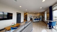 Located at 1520 Woerner Ave in Clarksville, Indiana, this thoughtfully designed single-floor residence offers a seamless open-concept layout that integrates the living, dining, and kitchen areas into one cohesive, light-filled space. Light wood-tone flooring flows throughout, complemented by neutral walls and bold dark-framed accents, including striking sliding barn doors that add a modern-industrial touch.

The kitchen is a standout feature, equipped with stainless steel appliances, crisp white cabinetry, a herringbone tile backsplash, and a spacious island with a quartz countertop and seating for multiple guests, illuminated by elegant pendant lighting. The open living area is bathed in natural light from floor-to-ceiling windows and sliding glass doors that lead directly to a private balcony, offering open outdoor views. A wall-mounted television and recessed lighting complete the space.

The bedroom is a tranquil retreat, featuring large windows, a ceiling fan, and ample natural light. The bathroom includes a glass-enclosed walk-in shower with tile surround, matte black fixtures, and convenient access to a walk-in closet. Throughout the residence, recessed lighting, dark door hardware, and a cohesive blue and neutral color palette create a polished, contemporary ambiance.