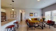 Located at 1001 Columbus Ave in Marysville, Ohio, this single-floor residence offers a thoughtfully designed layout with modern finishes and a bright, welcoming atmosphere. The open-concept living area is anchored by light wood-style flooring and large windows that flood the space with natural light while offering outdoor views. A private door leads to an exterior balcony, further enhancing the connection to the outdoors.

The kitchen features cream cabinetry, stainless steel appliances including a refrigerator, electric range, and built-in microwave, as well as a double-basin sink and sleek countertops. A peninsula with bar seating and pendant lighting creates a seamless transition into the living area, making it ideal for both daily living and entertaining.

Two well-proportioned bedrooms are finished with plush carpeting and windows that invite natural light. Each room offers a calm, comfortable retreat. The two bathrooms are finished with wood-style tile flooring, clean white cabinetry, and gray countertops. One bathroom features a full tub-shower combination, while the other offers a spacious vanity area. Together, the rooms create a cohesive, modern living environment with a neutral color palette and clean architectural lines throughout.
