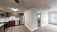 Located at 875 21st Ave SE in Rochester, Minnesota, this single-floor residence offers a well-designed layout that balances functionality and comfort. The open-concept living and kitchen area serves as the heart of the home, where durable wood-look vinyl flooring transitions seamlessly into carpeted living spaces. A ceiling fan adds both style and practicality to the main area, which benefits from large windows that invite natural light.

The kitchen is efficiently appointed with rich dark wood cabinetry, light stone-patterned countertops, and a full suite of stainless steel appliances, including a refrigerator, electric range, built-in microwave, and dishwasher. A stainless steel sink with a modern faucet completes the space.

The bedrooms feature plush carpeting and windows fitted with blinds, providing a comfortable and private retreat. Baseboard heating is present throughout, supplemented by a wall-mounted air conditioning unit in the primary bedroom area.

The bathroom is well-appointed with a granite-style vanity countertop, dark wood cabinetry for storage above the toilet, a full tub-shower combination, and textured walls that add character. The overall palette of neutral tones and textured ceilings creates a clean, cohesive ambiance throughout the residence.