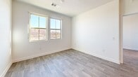 Located at 9465 W Post Rd in Las Vegas, NV, this well-designed 2-bedroom, 2-bathroom residence offers a thoughtful single-floor layout with clean, contemporary finishes throughout. Wood-look flooring runs seamlessly across the entire unit, creating a cohesive and modern aesthetic from entry to bedroom.

The open-concept living, dining, and kitchen area serves as the heart of the home. The kitchen is outfitted with white shaker-style cabinetry extending to the ceiling with glass-front upper cabinets, a subway tile backsplash, quartz countertops, stainless steel appliances including a gas range, microwave, and French door refrigerator, and a central island with pendant lighting overhead. The adjacent living and dining areas benefit from natural light through large windows with exterior views.

The spacious primary bedroom features two large windows with bright outdoor views and ample room for furnishings. Additional bedrooms are well-proportioned with access to the main living areas. The primary bathroom offers a long dual-sink vanity with quartz countertops, backlit mirrors, and wood-look tile flooring. A second bathroom includes an in-unit washer and dryer combo for added convenience. The unit also includes multiple closets and a utility room, ensuring generous storage throughout.