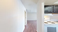 This 870 square foot apartment, located in the Summit West community, offers a thoughtful layout with two bedrooms and one bathroom. The space is characterized by its modern aesthetic, featuring sleek wood-look flooring throughout and crisp white walls that create a bright, airy atmosphere. The primary bedroom, measuring 170 square feet, provides ample space for relaxation and storage.

The living area is open and inviting, with large windows that flood the space with natural light. A ceiling fan adds both style and functionality to the room. The kitchen, while compact, is efficiently designed with dark wood cabinetry contrasting nicely against light countertops and white appliances. 

Both bedrooms offer good proportions and continue the apartment's light-filled theme with sizable windows. The closet space is generous, with a walk-in closet featuring built-in shelving systems for optimal organization. 

The apartment's single-floor layout ensures easy navigation and accessibility. With its blend of comfort, style, and practicality, this Summit West apartment presents an attractive option for those seeking a modern living space in a community setting.