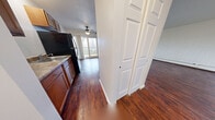 Located at 2015 E Henrietta Rd in Rochester, NY, this one-bedroom, one-bathroom unit offers a practical and well-organized single-floor layout. The combined living and dining area is a standout space, featuring rich, dark hardwood-style flooring, painted brick accent walls, large windows that invite natural light, and a sliding glass door that opens to a private balcony with outdoor views. Baseboard heating runs along the perimeter, and a wall-mounted A/C unit ensures year-round comfort. The kitchen is efficiently designed in a galley style, equipped with warm wood cabinetry, granite-toned countertops, and black appliances including a refrigerator, electric range, and microwave. A ceiling fan overhead adds airflow to the adjoining living space. The bedroom is a comfortable, well-sized retreat finished with plush wall-to-wall carpeting, a painted brick accent wall, and a bright window with natural light. Four closets throughout the unit provide generous storage. The full bathroom features tile flooring, a wood-toned vanity with a white countertop, and a tub/shower combination. Two hallways connect the spaces efficiently, completing this functional and comfortable layout.