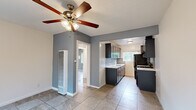 Located in the West Adams neighborhood of Los Angeles, this single-story, 3-bedroom, 1-bathroom home offers a practical and well-organized layout across one floor. Tile flooring runs consistently throughout the entire space, providing a cohesive look and easy maintenance.

The kitchen stands out as a highlight of the home, featuring dark cabinetry with modern hardware, white quartz countertops, a stainless steel undermount sink, a gas range, and a full-size refrigerator. A subtle mosaic tile backsplash adds texture and style, while a window above the sink fills the space with natural light and views of surrounding greenery.

Each of the three bedrooms is finished with cool-toned blue-gray walls and equipped with ceiling fans for comfort. The primary bedroom is notably spacious and includes mirrored sliding closet doors that enhance the sense of openness, along with wide windows that let in ample natural light. The additional bedrooms are bright and versatile, each with windows providing outdoor views.

The bathroom is clean and functional, featuring a full-size soaking tub and shower combination, tile flooring, a vanity, and a frosted window for privacy with natural light. A wall-mounted heater unit is also present in the main living area, ensuring year-round comfort. The home's straightforward floor plan, connected by two hallways, offers efficient flow throughout.