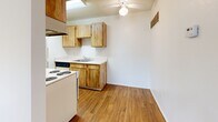 Located at 5025 N 1st Ave in Tucson, Arizona, this one-bedroom, one-bathroom unit offers a practical and efficiently designed single-floor layout. The living area features warm wood-look flooring, crisp white walls, and a textured ceiling with a ceiling fan, creating a bright and functional space. A ceiling fan serves the combined living and kitchen area, providing airflow and light throughout.

The galley-style kitchen is well-appointed with natural wood cabinetry lining both walls, offering ample upper and lower storage. White laminate countertops, a stainless steel sink, an electric coil range, and a full-size refrigerator complete the kitchen's functional setup. A skylight overhead adds a touch of natural brightness to the cooking space.

The bedroom is carpeted for comfort and features a large sliding window with louvered shutters that allow for adjustable natural light and ventilation. The textured ceiling continues throughout, maintaining a consistent aesthetic.

The bathroom is clean and straightforward, featuring wood-look flooring, a single vanity with a mirror, a toilet, and a full tub-shower combination with light-toned surround panels. The overall design of this unit prioritizes functionality and ease of living, making it a practical option in the Tucson area.