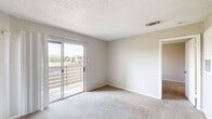 Located at 681 N Saginaw Blvd in Saginaw, TX, this single-floor residence offers a practical and comfortable layout across three bedrooms, a living room, dining room, kitchen, and a closet. The living room serves as the heart of the home, featuring a white brick-tiled fireplace, soft carpeting, a ceiling fan, and sliding glass doors that open to an outdoor balcony with neighborhood views, filling the space with natural light. Adjacent to the living area, the dining room flows seamlessly for everyday functionality. The galley-style kitchen is equipped with white cabinetry, a double-basin sink, light countertops, and wood-look vinyl flooring, providing an efficient and clean workspace. The primary bedroom is a well-proportioned retreat with sliding glass door access to the balcony and plush carpeting. The additional bedrooms each feature ceiling fans, carpet flooring, and windows that bring in natural light. One bedroom benefits from a connected bathroom. The dedicated closet space includes built-in shelving and washer/dryer hookups, adding practical utility. Neutral wall tones, textured ceilings, and consistent finishes throughout create a cohesive and move-in-ready atmosphere.