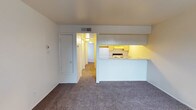 Located at 1520 University Blvd NE in Albuquerque, New Mexico, this single-floor unit offers a straightforward and functional layout designed for comfortable everyday living. The living area is carpeted and open, with neutral walls and a connected hallway leading to the private areas of the unit. A peninsula-style kitchen divides the living space, featuring upper and lower cabinetry with light-toned finishes, a coil electric range, a stainless steel sink, and laminate wood flooring — providing a practical workspace for cooking. The kitchen's pass-through design keeps the living area connected and accessible. A front entry door with a large window dressed in vertical blinds allows natural light to fill the main living space, adding brightness to the room. The bedroom is generously sized with plush carpeting, neutral walls, and ample room for furnishings. The bathroom is clean and efficiently laid out, complete with a full tub-shower combination, a toilet, a single vanity sink with a wide mirror above, and overhead lighting. Throughout the unit, the design is clean and understated, offering a blank canvas that is easy to personalize. The unit's central Albuquerque location near the University provides convenient access to local amenities, transit, and the broader city.