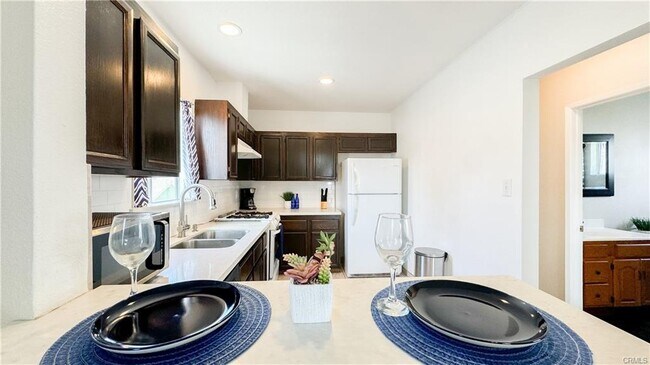 Kitchen w stove and fridge - 5853 Friends Ave